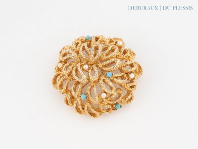 une image représentant une broche en or ornée de pierres turquoise sur un fond blanc