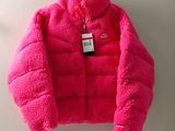 the pink jacket is hanging on a hook on the wall