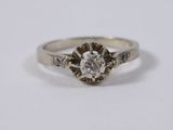 a close up of a diamond ring on a white surface