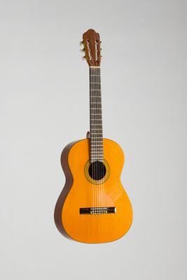 a close up of an orange guitar on a white background
