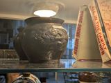 de nombreux vases et livres posés sur une étagère dans une pièce