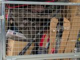 a metal cage filled with assorted items in the back of a truck