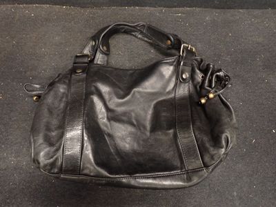 un sac à main noir posé par terre