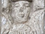 une sculpture en pierre représentant un homme coiffé d'un chapeau