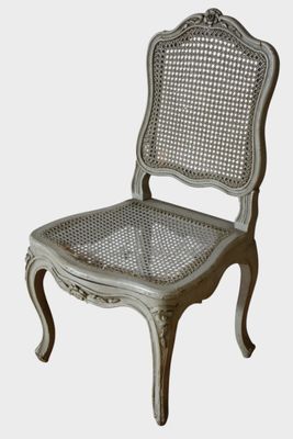 La chaise est en bois et son assise est en osier.