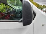 a white truck with a man in the driver ' s seat looking out the window