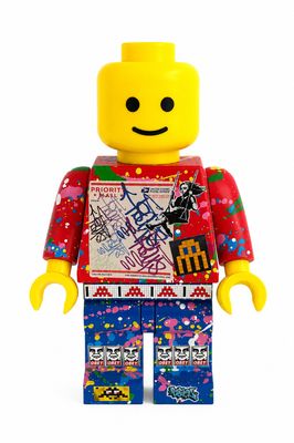 a lego man that is wearing a red shirt and blue pants