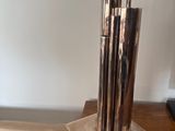 a silver vase with four pens in it on a wooden table