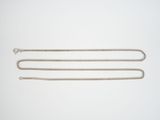 a close up of two silver chains on a white surface