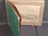an open book with a green cover on a table