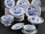 a group of blue and white plates and bowls on a table