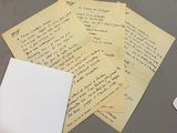 a pile of papers on a table next to a computer mouse