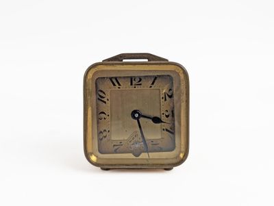 a small clock that is sitting on a white surface