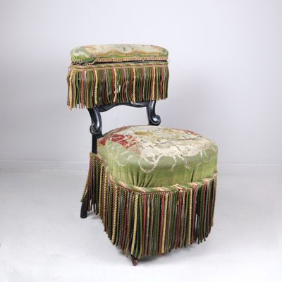 une image représentant une chaise avec un repose-pieds et un tabouret sur lequel est posé un coussin