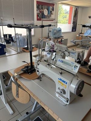 un homme debout devant une machine à coudre