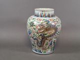 un vase orné d'un dragon posé sur une table