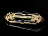 a close up of a diamond and sapphire broochle on a black surface