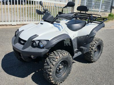 an image of a white four wheeler atv parked in a parking lot