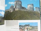 an open book with a picture of a castle in the background