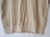 a close up of a sweater on a hanger on a wall