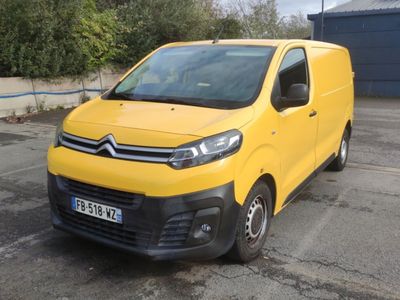 une camionnette Citroën garée sur un parking devant un immeuble