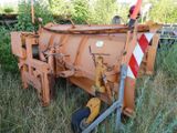 a tractor that is parked in the grass near a fence