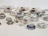 une table blanche sur laquelle sont disposés de nombreux petits plats et tasses