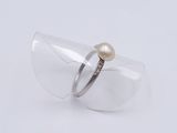 a close up of a ring with a pearl on it