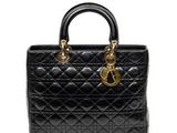 un sac à main noir avec des finitions dorées sur la poignée