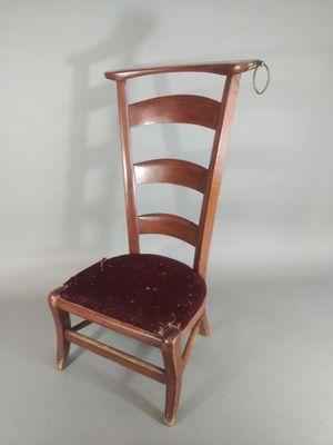 a wooden chair with a red seat on a white background