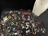 many different necklaces and bracelets laid out on a table