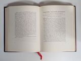 a book open on a table with a red ribbon