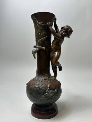 a bronze statue of a boy climbing a tree