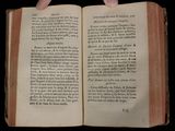 someone is holding an open book in their hands on a black background
