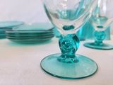 a blue glass with a rose on it sitting on a table