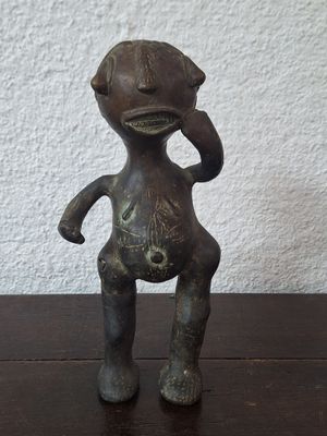 a small statue of a person on a wooden table
