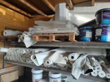 several cans of paint on a shelf in a garage