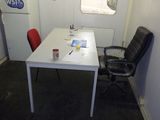 une table blanche avec une chaise rouge et une chaise noire