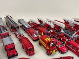 a lot of toy fire trucks and cars on the table