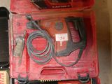 une boîte rouge contenant des outils, posée sur le sol