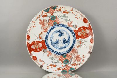 une assiette orange et bleue ornée d'un motif représentant des fleurs et des oiseaux