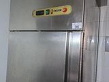 un réfrigérateur en acier inoxydable dans une cuisine, avec une affiche sur la porte