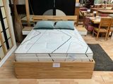un lit avec un cadre en bois et un matelas posé dessus