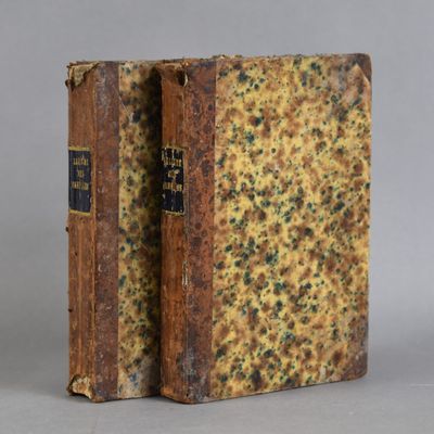 an old book sitting on top of a table next to a gray wall