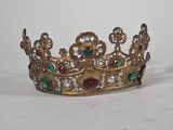 gold crown with jewels and gems on it on a white surface