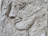 relief représentant le visage d'une femme sur un bloc de pierre