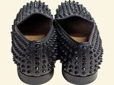 the black spiked shoes are on a white surface