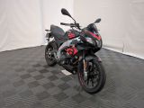 une moto noire et rouge garée dans une pièce