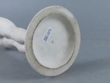 a white porcelain vase with a handle on a table