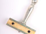 a wooden stamp with a metal handle on a white surface